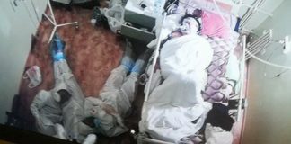 Tres trahado di salud Ruso ta drumi abao despues di un nochi di vigilancia hunto cu e cama di un pashent cu COVID-19