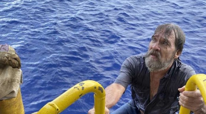 Ta rescata un marinero bibo haya ta flota riba un pida di su boto cu a sink riba lama