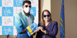 Prome minister ta entrega bandera di Aruba na atleta paralimpico Elliott Loonstra.
