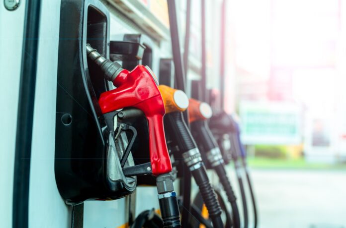 Petrol pump filling fuel nozzle in gas station. Fuel dispenser machine. Refuel fill up with petrol gasoline. Petrol industry and service. Red petrol fuel nozzle. Petroleum oil industry. Oil crisis.