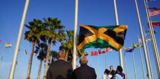 Riba Dia di Independencia di Jamaica, a hisa e bandera Jamaiquino pa prome bes na rotonde di Aeropuerto Internacional Reina Beatrix