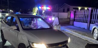 Dama na stuur di un auto Chevrolet a hala na su man drechi y a dal contra un Ford Lincoln staciona