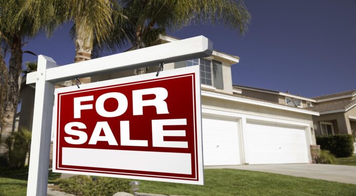 For Sale Real Estate Sign in Front of House.