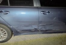 Polis a detene chauffeur di edad burachi cu a sali raspa auto for di parkeerplaats